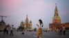 FILE - A young woman checks her smartphone at Red Square in Moscow, Russia, July 25, 2016. Russians may haver their access to Facebook blocked if the social media giant does not start storing Russian user data locally.