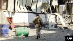 FILE - Members of the Yemeni pro-government forces walk through destruction in an industrial district in the eastern outskirts of the port city of Hodeida on Nov. 18, 2018, during the ongoing battle for control of the city from the Houthi rebels. 