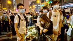 民主派油尖旺區議員林兆彬（左一）8月31日晚在太子地鐵站出口擺放大型紙箱，協助市民獻花紀念8-31警方涉嫌無差別襲擊市民事件一周年。(美國之音湯惠芸攝）