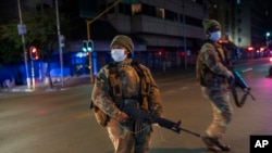 Les forces de sécurité sud-africaines patrouillent dans le centre-ville de Johannesburg, en Afrique du Sud, le vendredi 27 mars 2020, pendant le confinement visant à limiter la propagation du nouveau coronavirus.