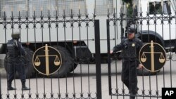 FILE - Police officers guard a court building in Rostov-on-Don, Russia, Sept. 15, 2015. On Monday, a Russian military court in western city of Penza sentenced seven members of a left-wing group to prison terms of up to 18 years on terrorism charges. 