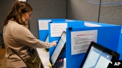 Courtney Parker votes on a new voting machine, Nov. 5, 2019, in Dallas, Georgia.