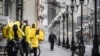A man walks along pedestrian Arbat street as food delivery couriers talk to each other, in downtown Moscow, April 14, 2020. 
