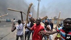 Jovens contstando os resultados eleitorais na cidade do Kano no norte da Nigéria