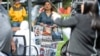 A woman holds images, some showing former Lebanon Prime Minister Rafik Hariri, outside the United Nations-backed Lebanon Tribunal in Leidschendam, Netherlands, Aug. 18, 2020.