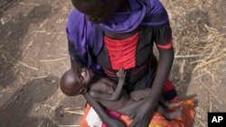 Adel Bol, 20 ans, berce sa fille de 10 mois, Akir Mayen, à Malualkuel dans la région de Bahr el Ghazal au Soudan du sud.