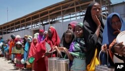 FILE - Watoto waliokimbia ukame katika eneo la kusini mwa Somalia wakiwa wanasubiri msaada wa chakula katika kituo cha kugawa chakula katika kambi moja Mogadishu, Somalia. 