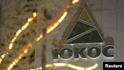 FILE - The Yukos logo is seen in its Cyrillic rendering on the wall of the headquarters building of the now defunct oil giant in the Russia's northern city of Nefteyugansk, Dec. 19, 2004.