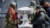 Visitors waiting to collect free food outside the Bowery Mission are instructed to wash their hands at a kiosk due to coronavirus concerns, April 1, 2020, in New York.