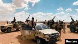 FILE- Troops loyal to Libya's internationally recognized government patrol the area in Zamzam, near Abu Qareen, Sept. 15, 2020.