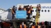 Trabajadores descargan contenedores de la vacuna rusa Sputnik 5 para COVID-19 en el Aeropuerto Internacional de El Alto, Bolivia, el 28 de enero de 2021.