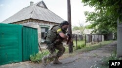 Ukrainian serviceman holds a gun during fighting in Mariinka, in the region of Donetsk, June 4, 2015.