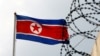 FILE PHOTO: A North Korea flag flutters next to concertina wire at the North Korean embassy in Kuala Lumpur