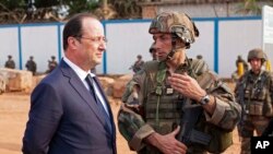 Le président français François Hollande, à gauche, en pleine discussion avec des hommes des troupes françaises à Bangui, en République centrafricaine, 28 février 2014. (AP Photo / Frederic Lafargue)