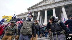 Wanachama wa kundi lenye itikadi kali ya mrengo wa kulia (Oath Keepers) wakisimama nje ya jengo la bunge la Marekani, Januari 6, 2021.