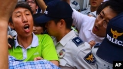 一名南韓進步黨成員(左)在首爾南部的水原市遭南韓情報局逮捕。
