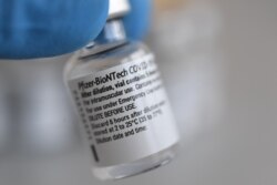 FILE - A vial contains doses of the Pfizer-BioNTech COVID-19 vaccine.