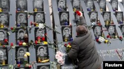 A man takes part in a commemoration ceremony, Nov. 21, 2019, at a monument to the "Heavenly Hundred," the anti-government protesters killed during the Ukrainian pro-European Union mass demonstrations in 2014, to mark the sixth anniversary of the uprising.