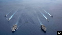 美國海軍照片顯示尼米茲號和里根號航空母艦組成的雙航母戰鬥群7月6日在南中國海航行。 （2020年7月6日）