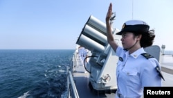 資料照：中國海軍女兵在中俄海軍在廣東湛江舉行的聯合海軍演習結束時向俄羅斯軍人揮手致意。 （2016年9月19日）