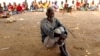 A man waits to receive food aid outside a camp for displaced survivors of cyclone Idai in Dombe, Mozambique, April 4, 2019. 