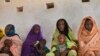 FILE - Mothers wait for their children to be examined for signs of malnutrition at a walk-in nutrition clinic in Barrah, a desert village in the Sahel belt of Chad, April 20, 2012. 