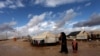 A Syrian refugee woman walks with her children at Zaatari Syrian refugee camp, near the Syrian border in Mafraq, Jordan, January 9, 2013.