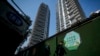 FILE - Residents walk by a luxury housing construction site in Beijing, Sept. 24, 2024. Over the past few months, regulators have rolled out a slew of policies meant to help reverse the downturn in the housing market and encourage more spending by Chinese households. 