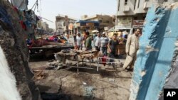 Civiles inspeccionan el sitio de un ataque suicida en Bagdad, Irak, el jueves, 17 de septiembre de 2015.