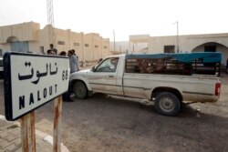 FILE - A van crosses the Tunisian-Libyan border of Dhuheiba, Tunisia, April 21, 2011.