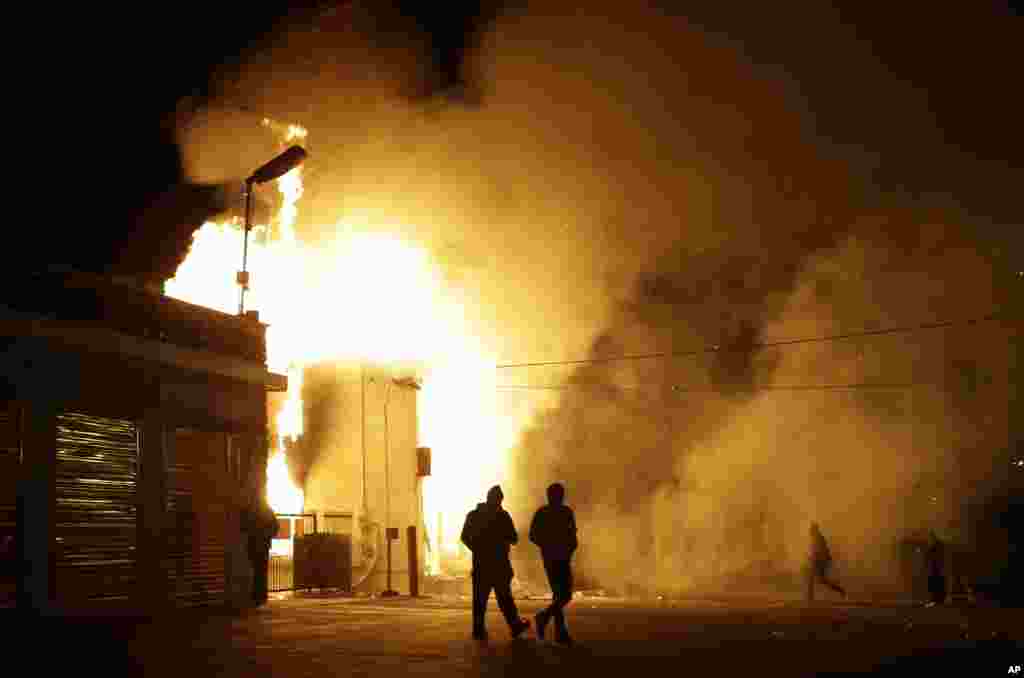 Des personnes marchent près d&#39;un entrepôt en feu après l&#39;annonce de la décision du grand jury, Ferguson, Missouri, le 24 novembre 2014.
