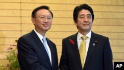 日本首相安倍晉三(右)在東京會晤到訪的中國國務委員楊潔篪