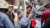 EDITORS NOTE: Graphic content / TOPSHOT - Um homem carrega o corpo de uma criança que foi resgatada dos escombros após os bombardeamentos israelitas na casa de quatro andares da família Muqat, no bairro de Zarqa, no norte da cidade de Gaza, em 26 de outubro de 2024