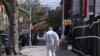 People wear face masks for protection against the coronavirus as the walk their dog on the Brooklyn Bridge in New York, April 10, 2020.