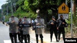 Petugas polisi Nikaragua memblokir wartawan yang bekerja di luar rumah pemimpin oposisi Cristiana Chamorro setelah jaksa mencari penangkapannya karena pencucian uang dan kejahatan lainnya, di Managua, Nikaragua, 2 Juni 2021. (Foto: Reuters)