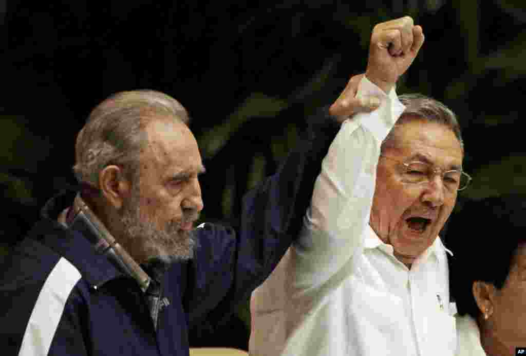 Fidel Castro, à gauche, soulève la main de son frère, le président cubain Raul Castro, au centre, en chantant l&#39;hymne du socialisme international lors du 6ème Congrès du Parti communiste à La Havane, Cuba, 19 avril 2011. &nbsp;