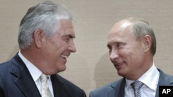 Waziri Mkuu wa Rashia Vladimir Putin, kulia, na Rex Tillerson, na mkuu wa ExxonMobil wakizumgumza kwa faragha mjini Sochi, Russia, Jumanne, Aug. 30, 2011