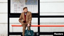 FILE - A man sits by himself at a bus stop in London, Oct. 18, 2013. Health Secretary Jeremy Hunt said at the time that there were hundreds of thousands of people in England who were chronically lonely. A "minister of loneliness has now been appointed to 