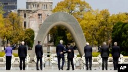 Le secrétaire d 'Etat américain John Kerry, au centre, et le ministre japonais des Affaires étrangères Fumio Kishida ont déposé des couronnes à l'Hiroshima Peace Memorial Park.
