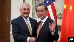 Poignée de main entre le ministre chinois des Affaires étrangères Wang Yi et le secrétaire d'État américain Rex Tillerson avant une réunion bilatérale au Diaoyutai State Guesthouse à Pékin, Chine, le 18 mars 2017.