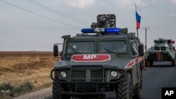 FILE - Russian forces patrol near the city of Qamishli, north Syria, Oct. 24, 2019.