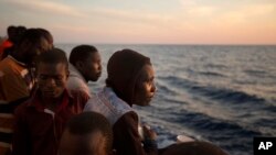 Les migrants subsahariens se tiennent sur le pont du navire de secours Golfo Azzurro près du port de Pozzallo, en Italie, le 17 juin 2017.