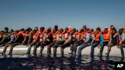 Migrants en provenance du Mali et d'autres pays africains attendant d'être secourus en mer Méditerranée, le 19 juillet 2016