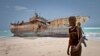 Perompak Somalia berdiri di dekat kapal nelayan yang terdampar.