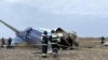 Petugas tanggap darurat memeriksa bagian pesawat Azerbaijan Airlines yang mengalami kecelakaan di dekat Kota Aktau, Kazakhstan, pada 25 Desember 2024. (Foto: Kazakhstan Emergencies Ministry/Handout via Reuters)