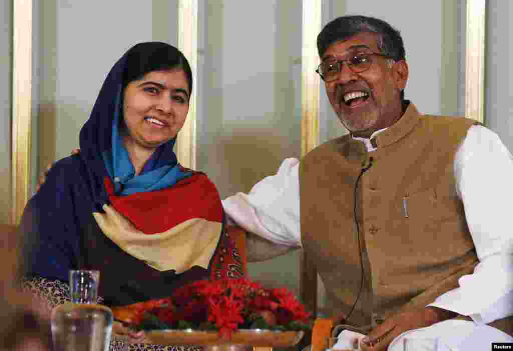 Nobel Peace Prize laureates Kailash Satyarthi (R) and Malala Yousafzai react during a news conference in Oslo Dec. 9, 2014. 