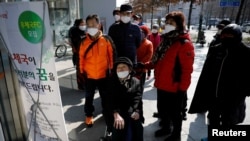 南韓新冠病毒確診病例不斷攀升，重災區大邱市民眾閱讀有關郵局販賣口罩的說明(2020年3月5日)