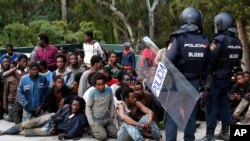 Des policiers espagnoles surveillent des migrants africains, à Ceuta, le 17 février 2017. 