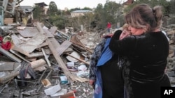A neighbor comforts homeowner Lida Sarksyan, left, near her house destroyed by shelling from Azerbaijan's artillery during a military conflict in Stepanakert, the separatist region of Nagorno-Karabakh, Oct. 17, 2020. (AP Image)