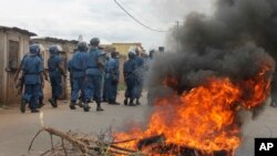 Des policiers antiémeutes marchent contre des manifestants dans les rues de Bujumbura, le 26 avril 2015.